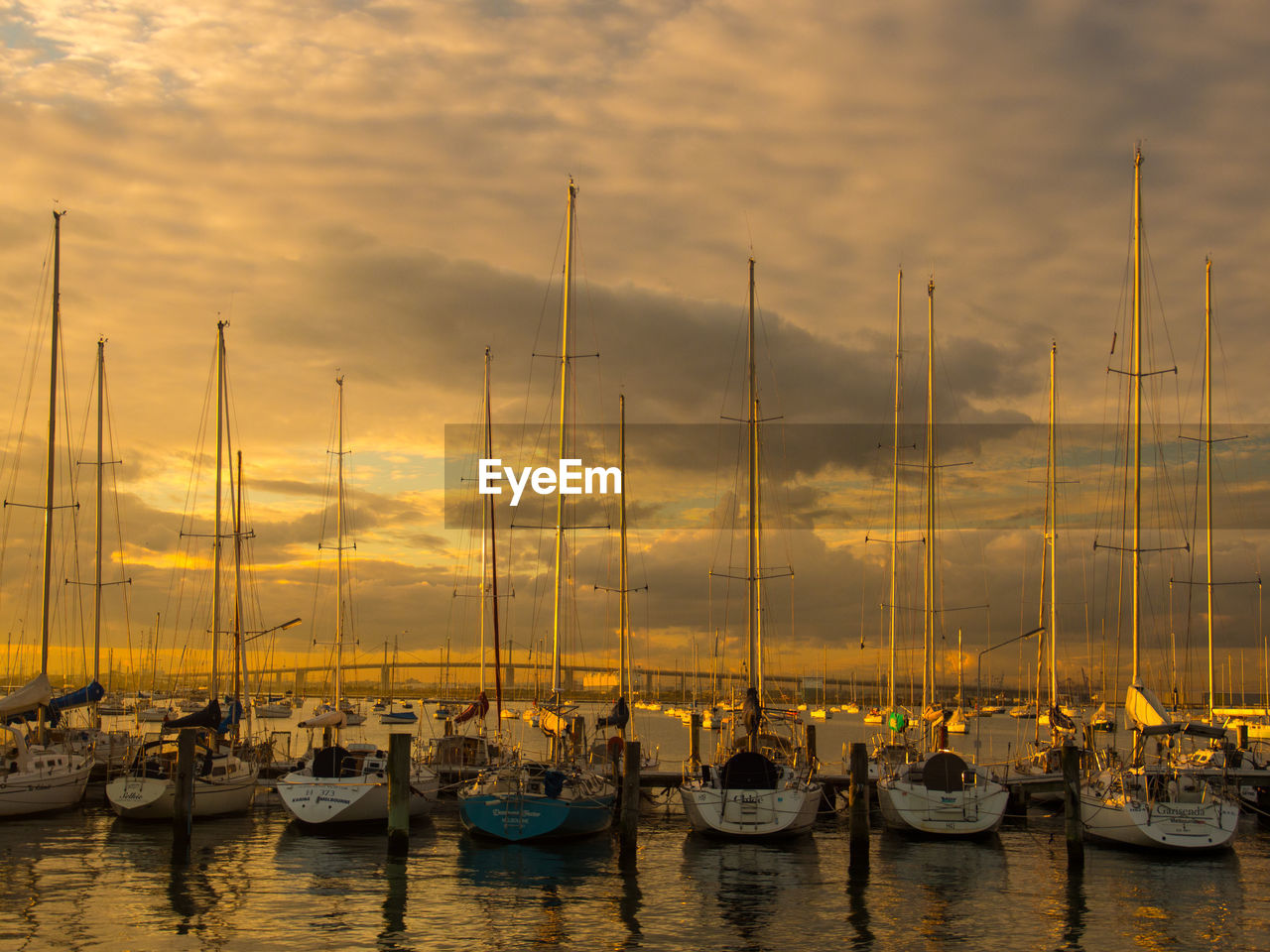 Boats moored in calm sea at sunset