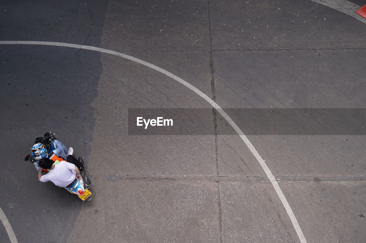 High angle view of woman sitting on road