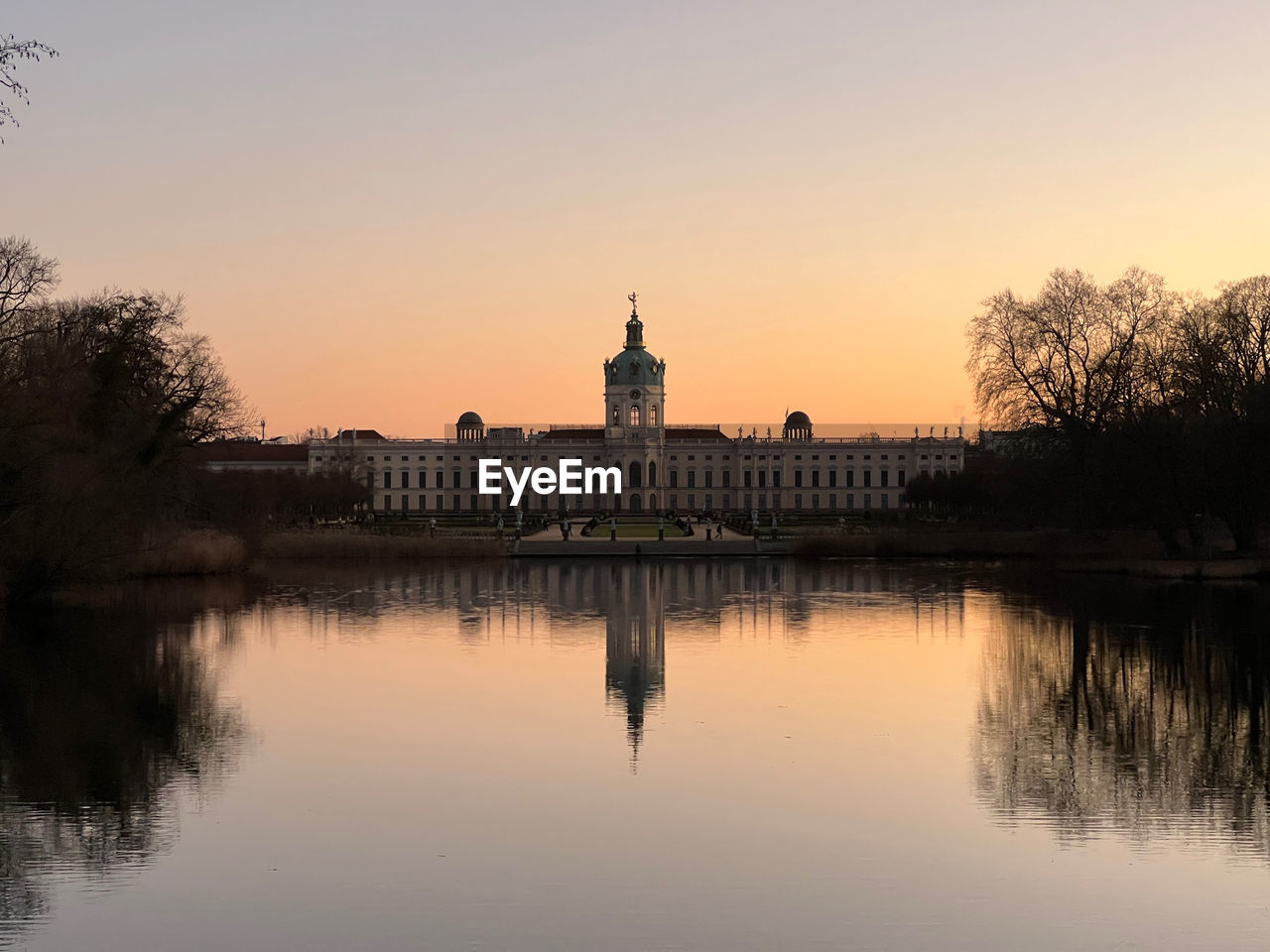 Reflection of charlottenburg palace in lake at dusk