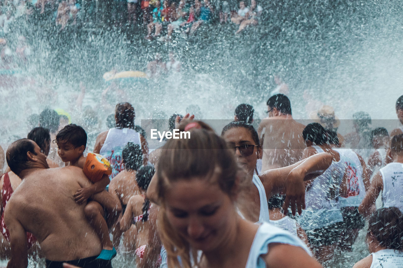 GROUP OF PEOPLE WATCHING SWIMMING IN POOL