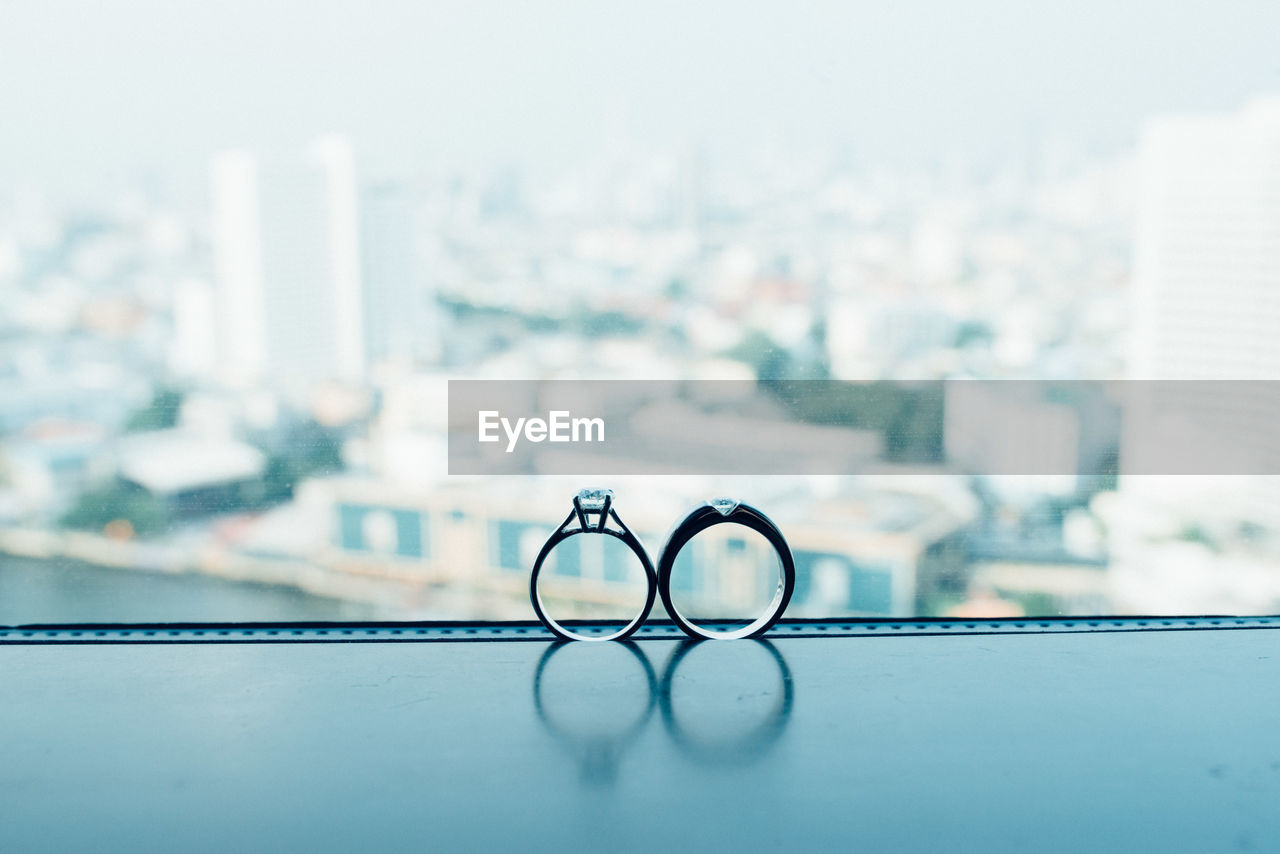 Close-up of wedding rings on window