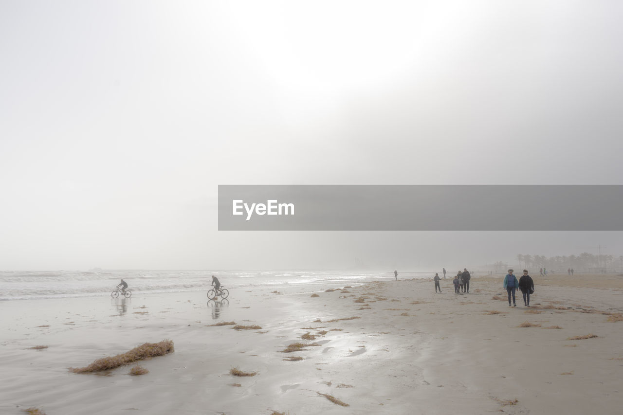 People on beach against sky