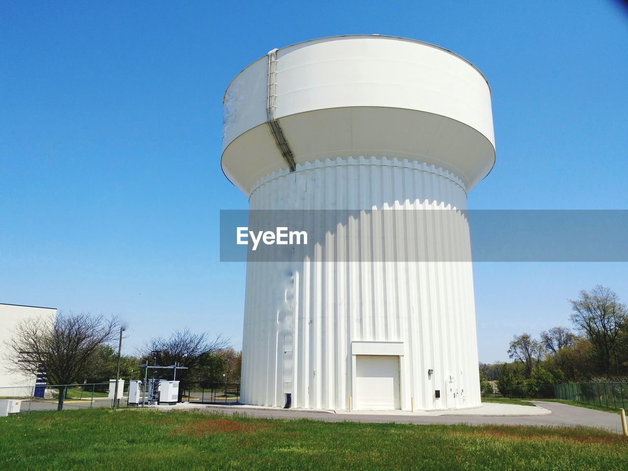 Built structure on field against clear blue sky