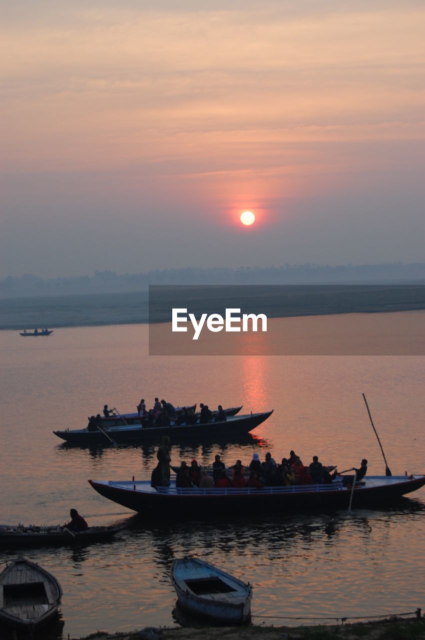 BOATS IN SEA AT SUNSET