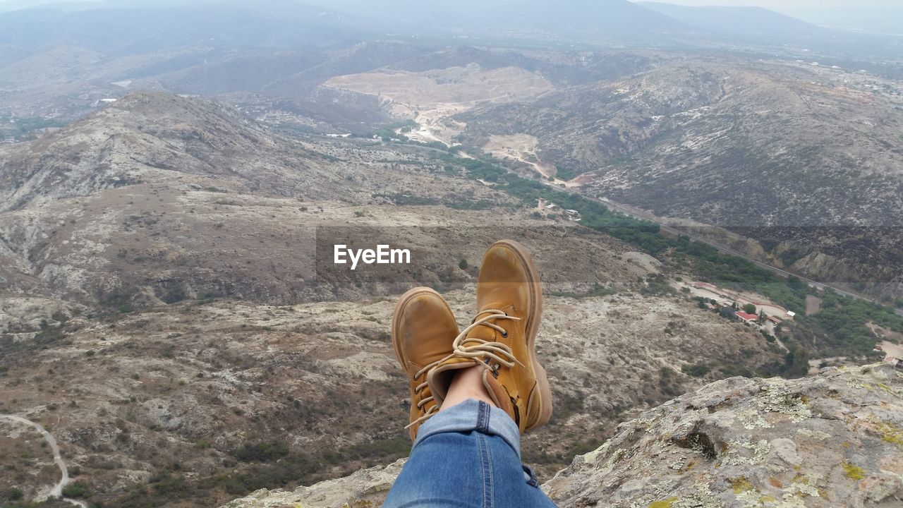 Low section of person sitting against landscape