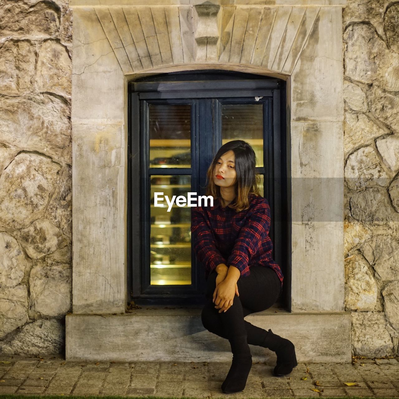 Portrait of woman sitting at entrance of building