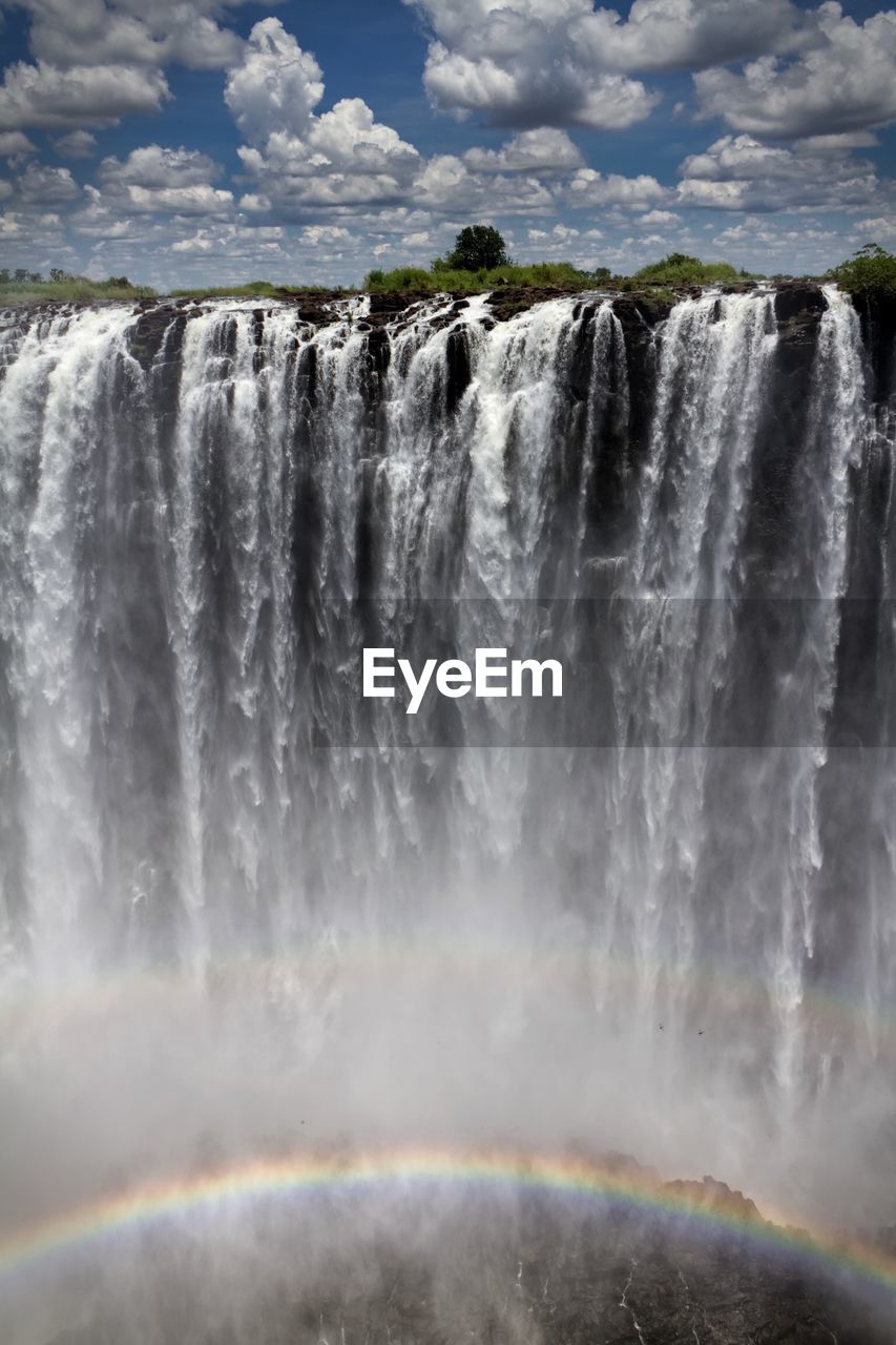 Scenic view of waterfall against sky