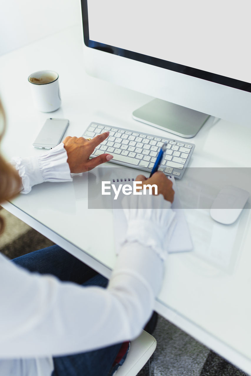 Midsection of businesswoman working in office