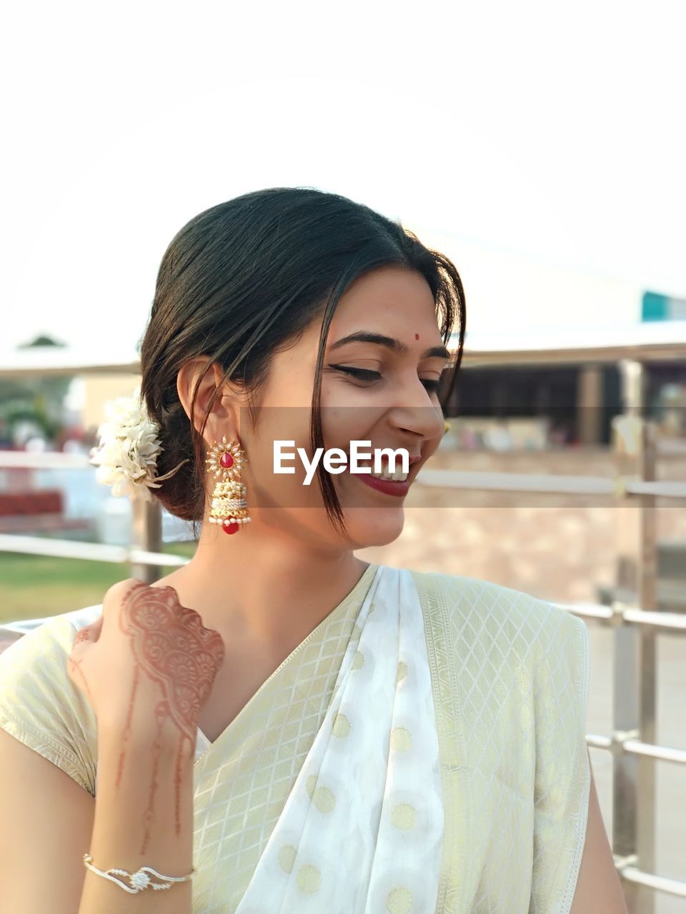 Close-up of smiling beautiful woman wearing earring and sari while standing outdoors