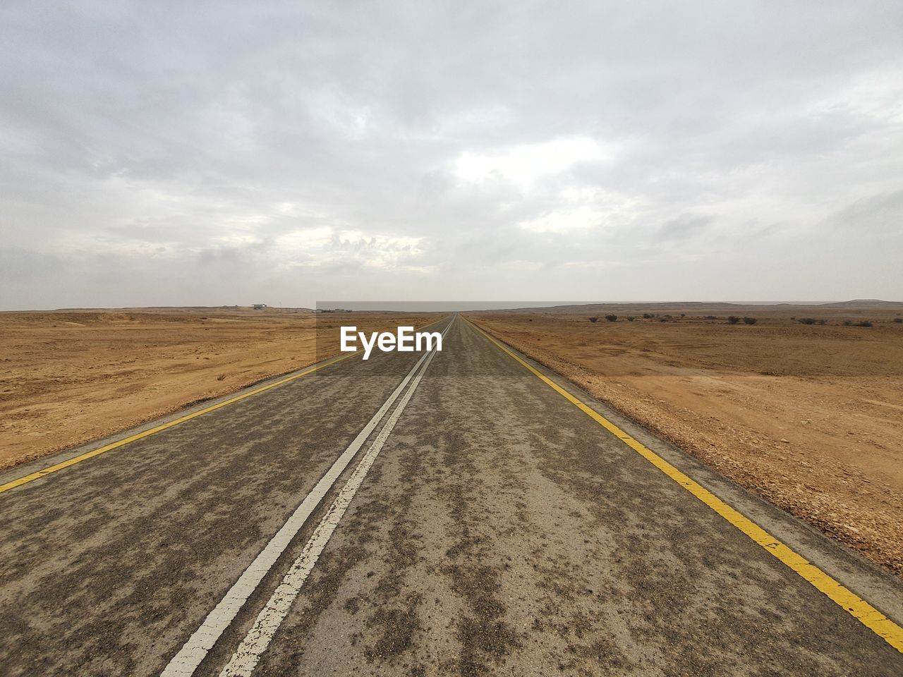 Road amidst field against sky