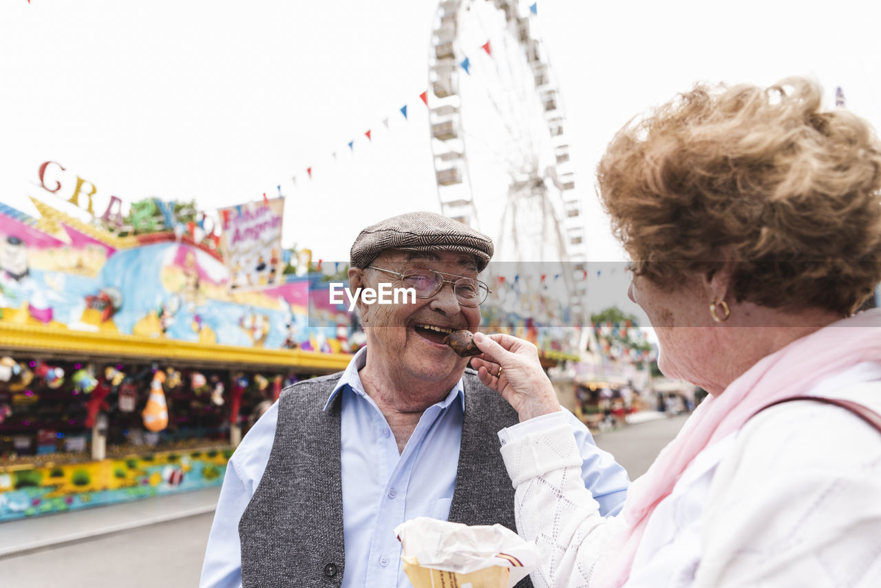 Portrait of happy senior man having fun with his wife on fair