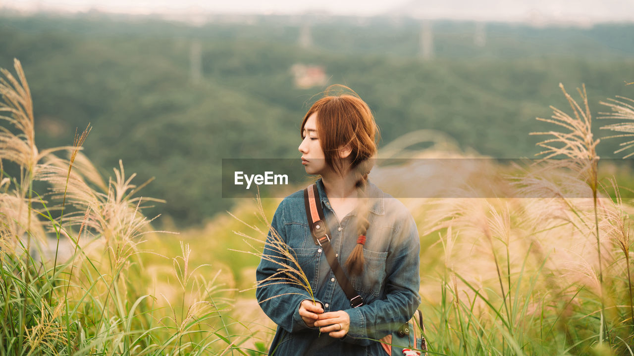 Beautiful young woman standing at farm