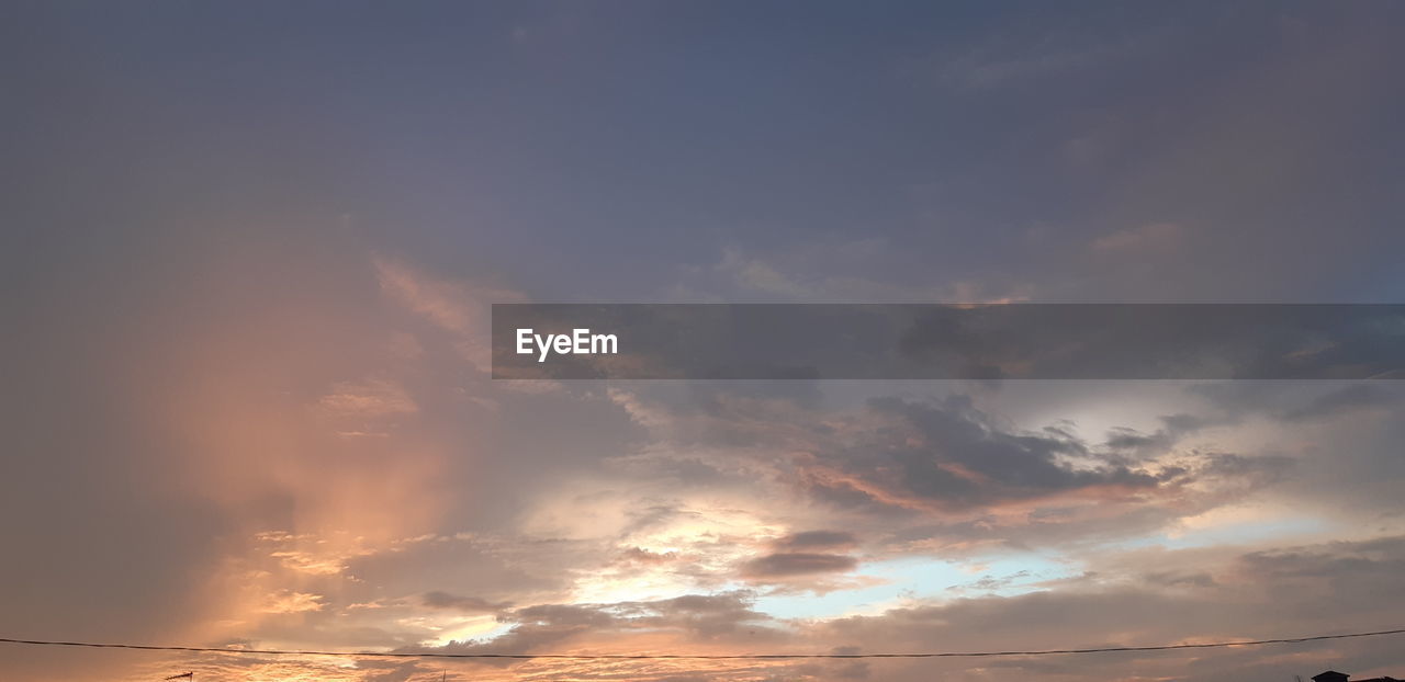 LOW ANGLE VIEW OF SUN STREAMING THROUGH CLOUDS