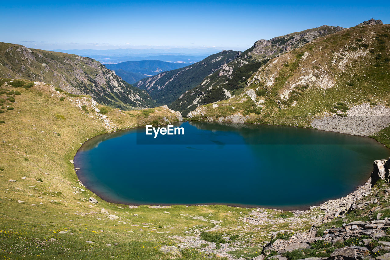 HIGH ANGLE VIEW OF LAKE AMIDST MOUNTAINS AGAINST SKY
