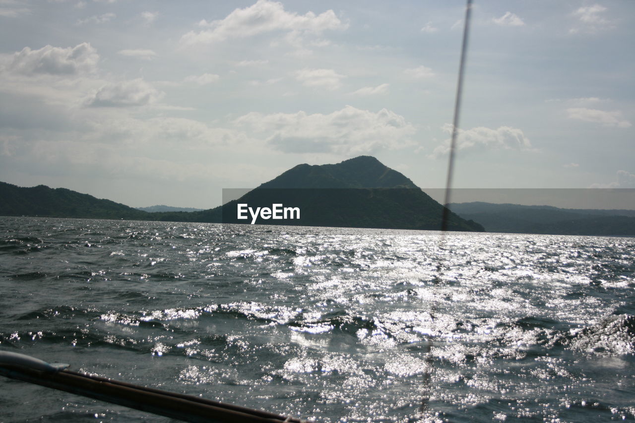 SCENIC VIEW OF SEA AGAINST MOUNTAINS