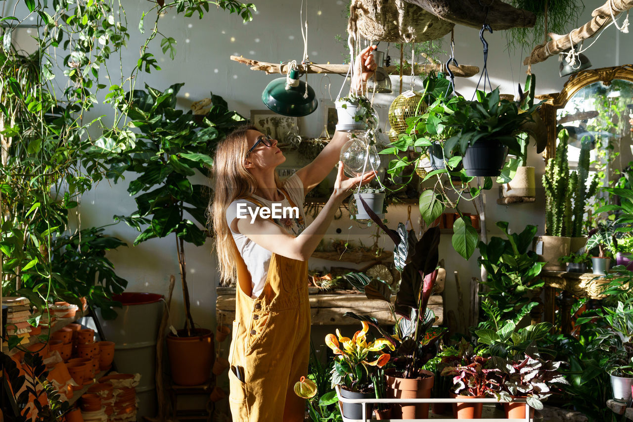 Woman standing by potted plants