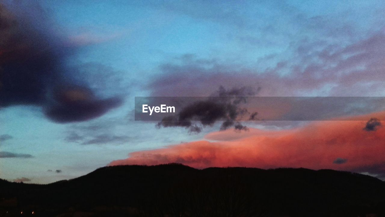 LOW ANGLE VIEW OF DRAMATIC SKY OVER SILHOUETTE MOUNTAIN