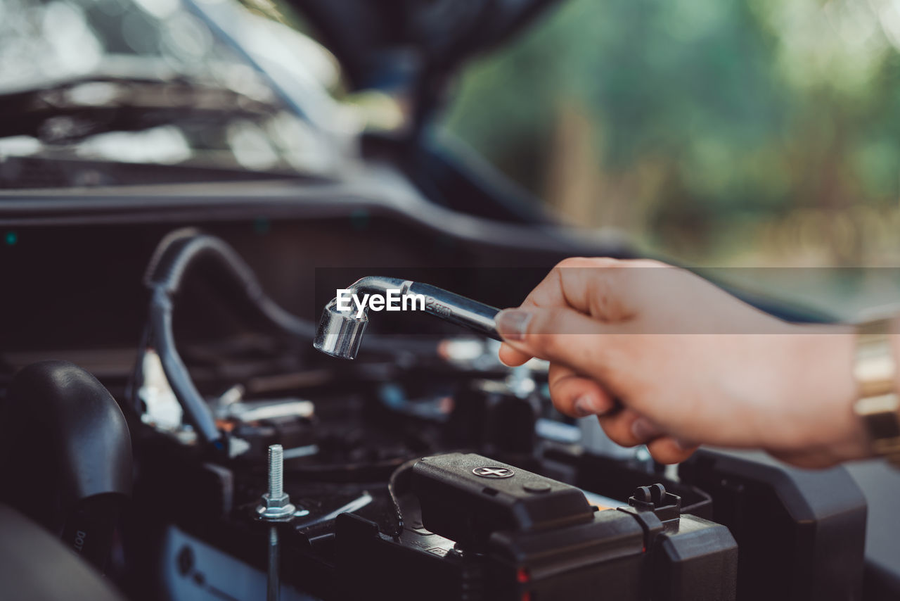 Cropped hand of woman repairing car