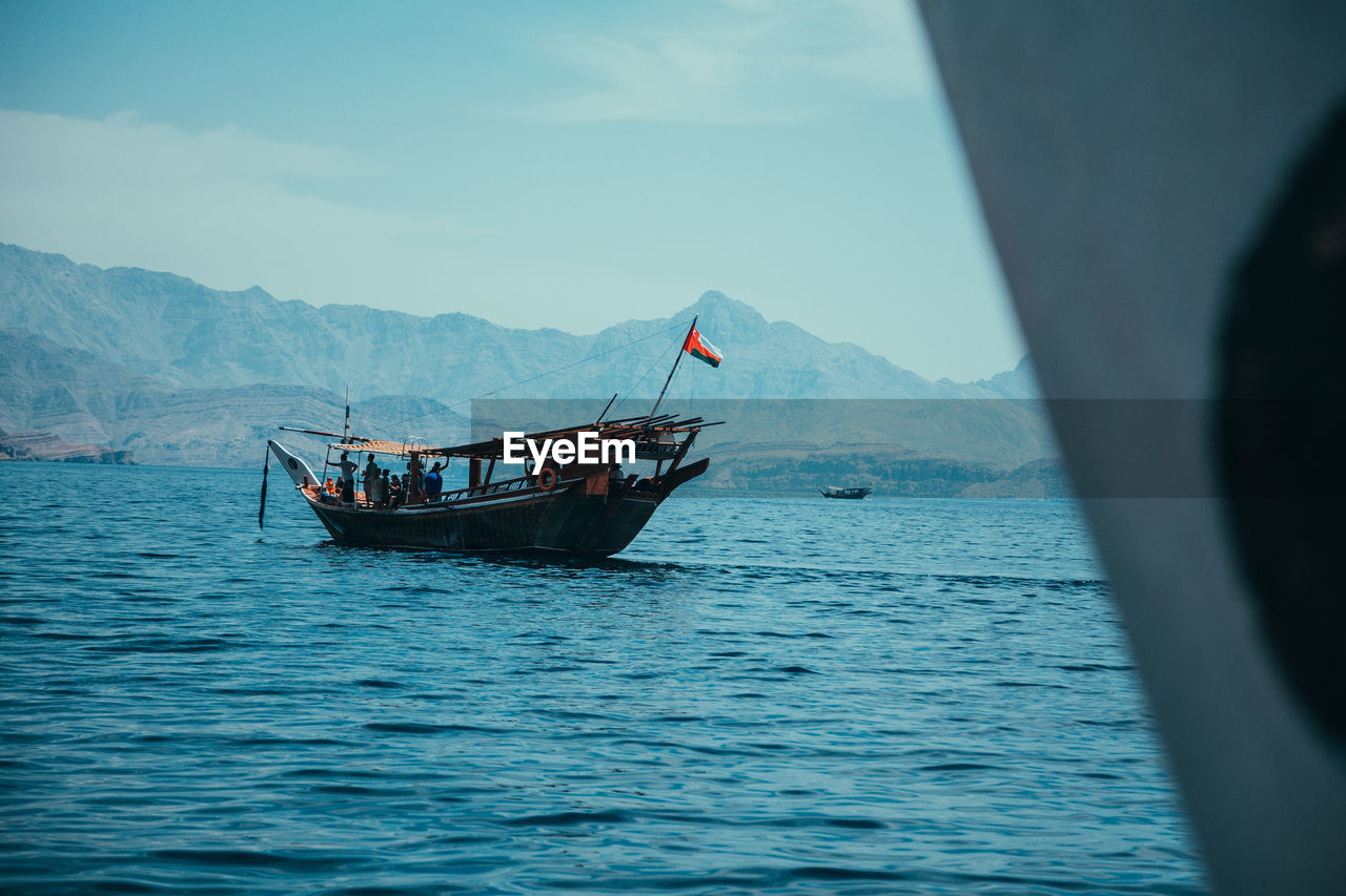 Boat sailing in sea against sky