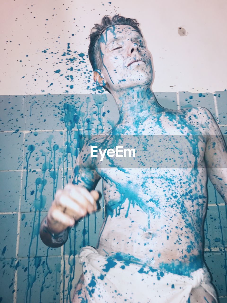 Shirtless man with paint in bathroom