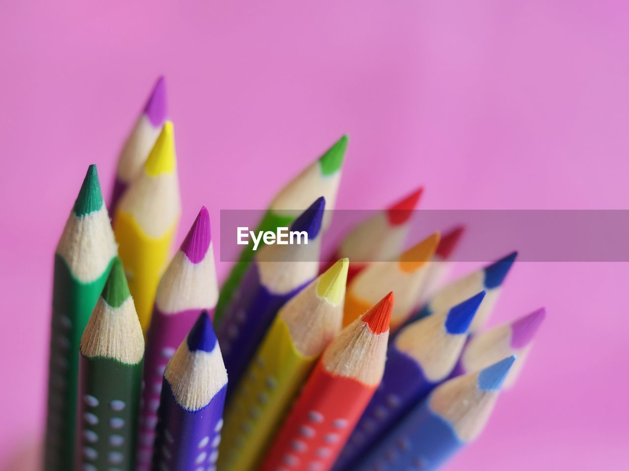 Close-up of multi colored pencils against purple background