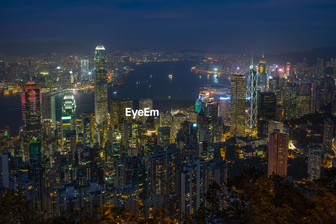 Illuminated cityscape against sky at night