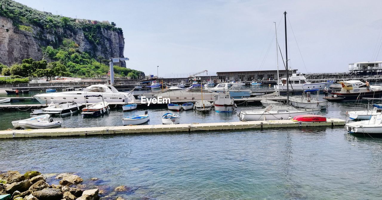 SAILBOATS MOORED AT HARBOR