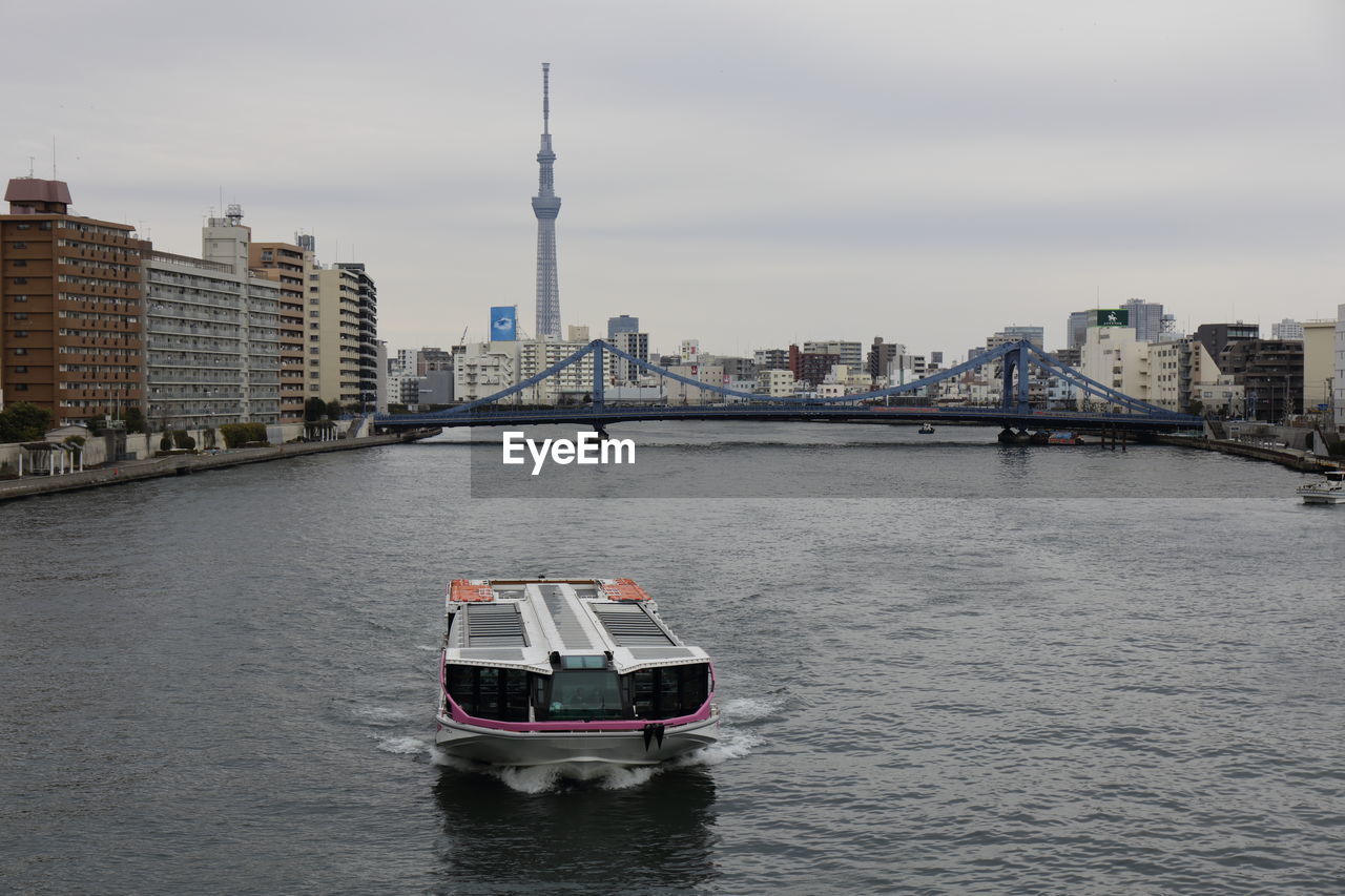 Boat in river with city in background