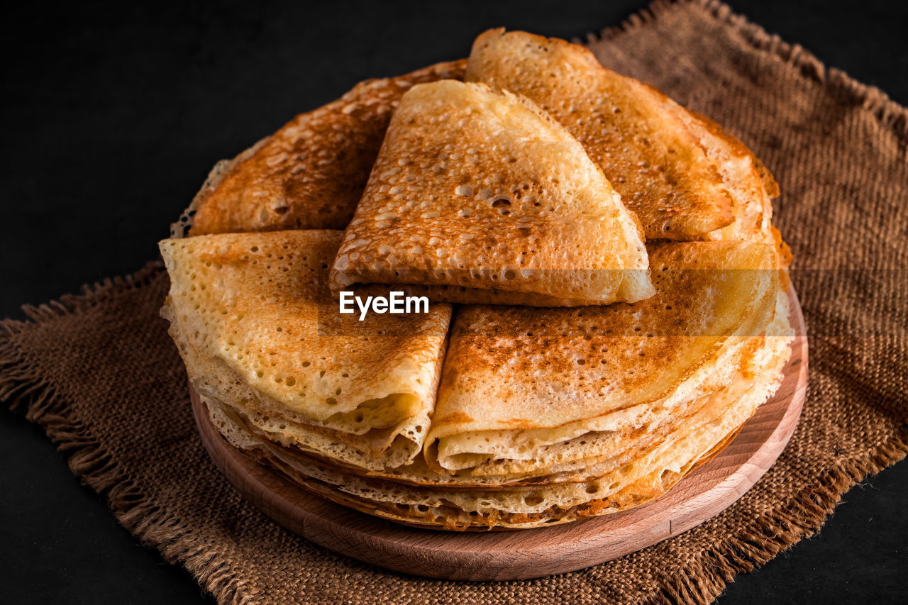 A stack of delicious pancakes on a black background. food for the holiday maslenitsa. 