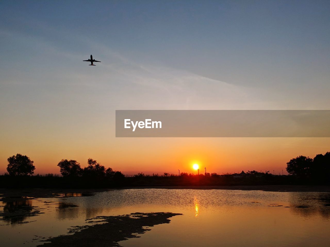 Scenic view of silhouette plane against sky during sunset