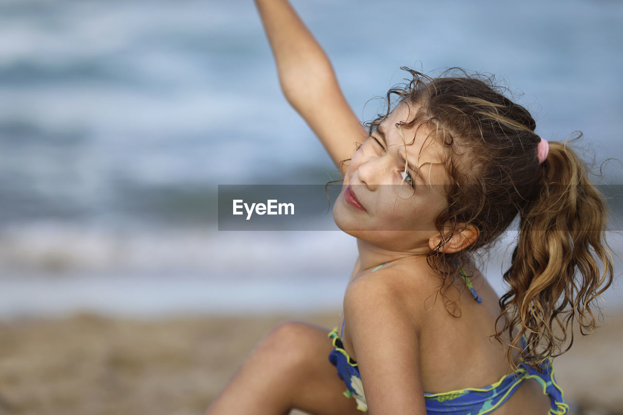 side view of young woman swimming in sea at beach