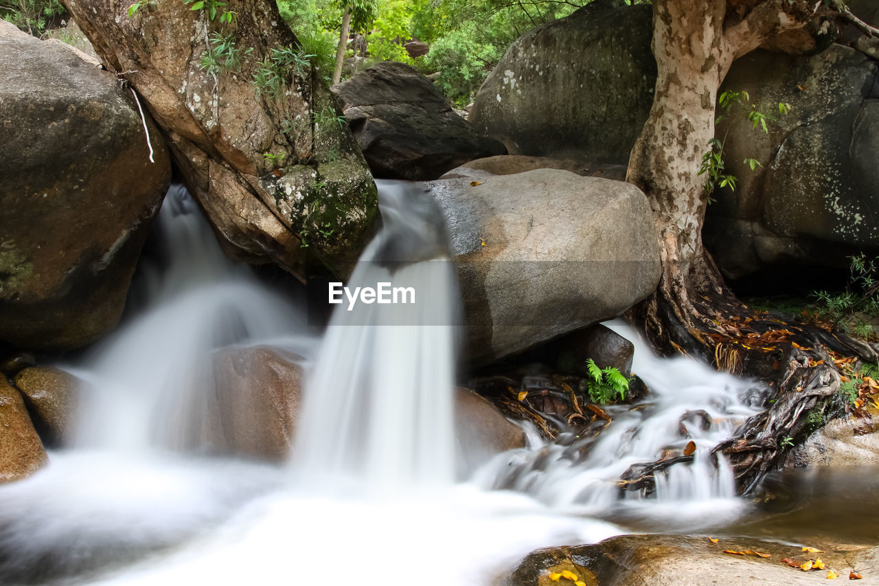 Idyllic small waterfall over big rocks in australian rainforest