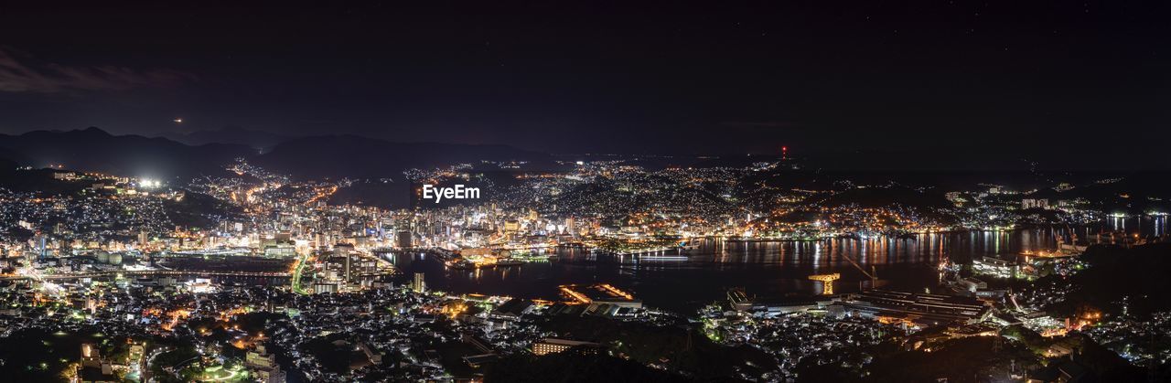 HIGH ANGLE VIEW OF ILLUMINATED BUILDINGS AT NIGHT