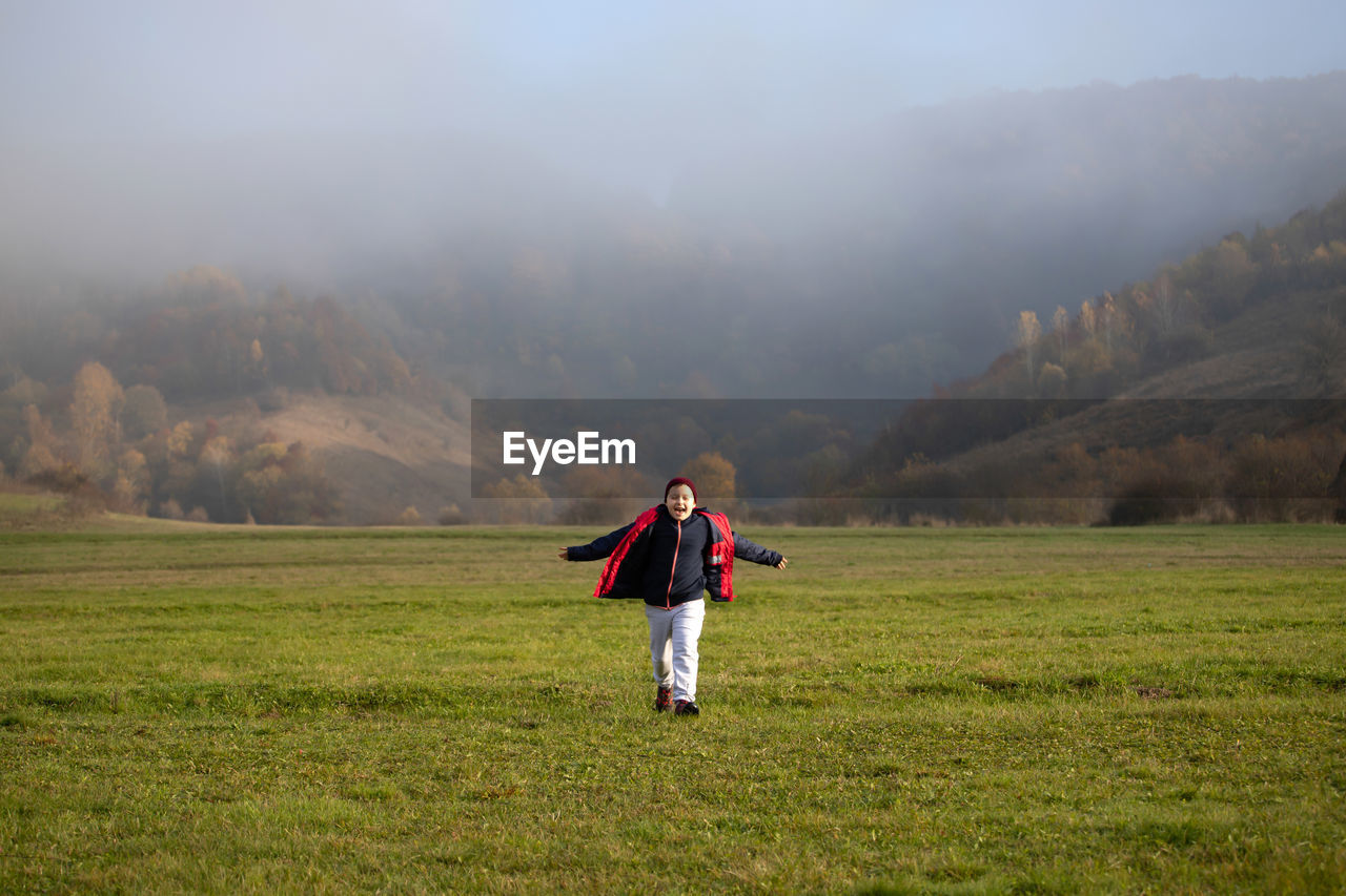 Full length of man standing on field during foggy weather