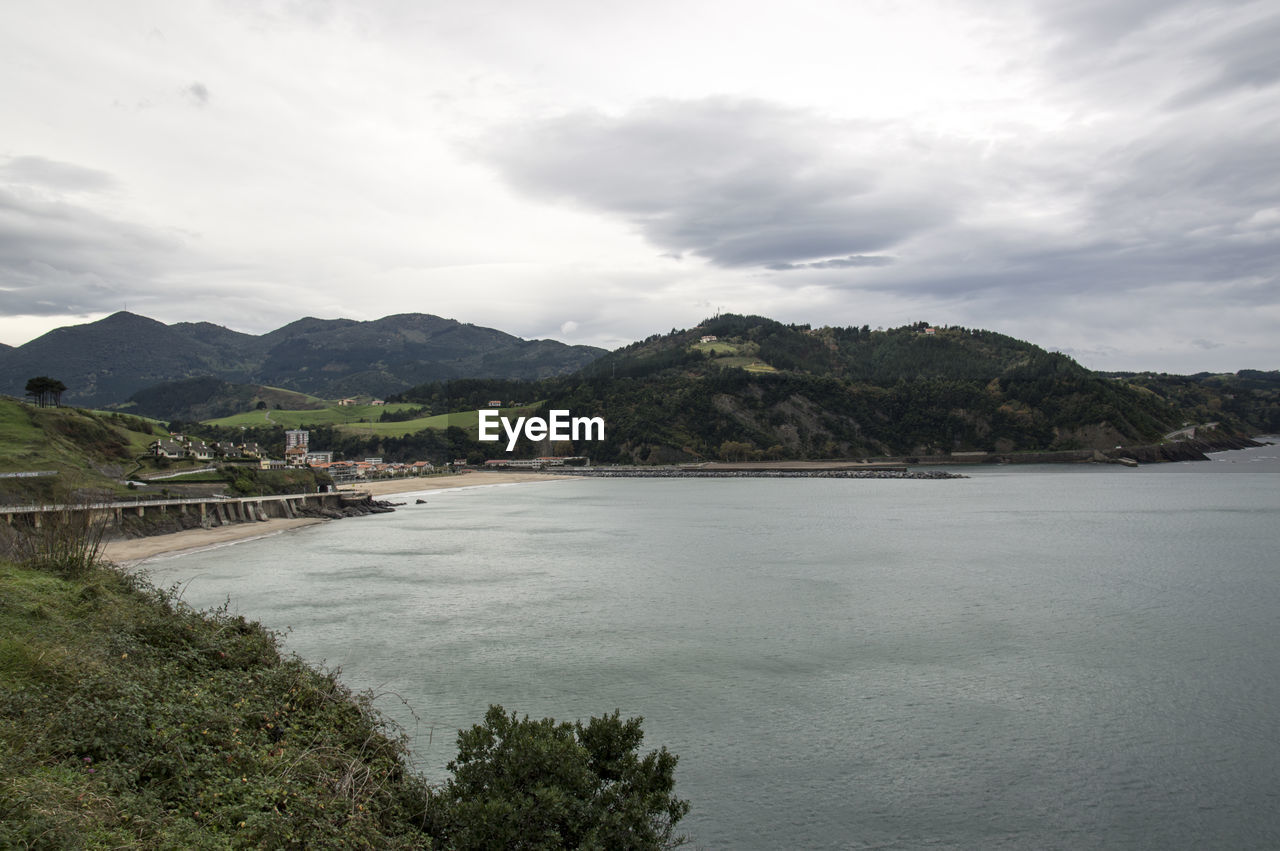 Scenic view of sea and mountains against sky