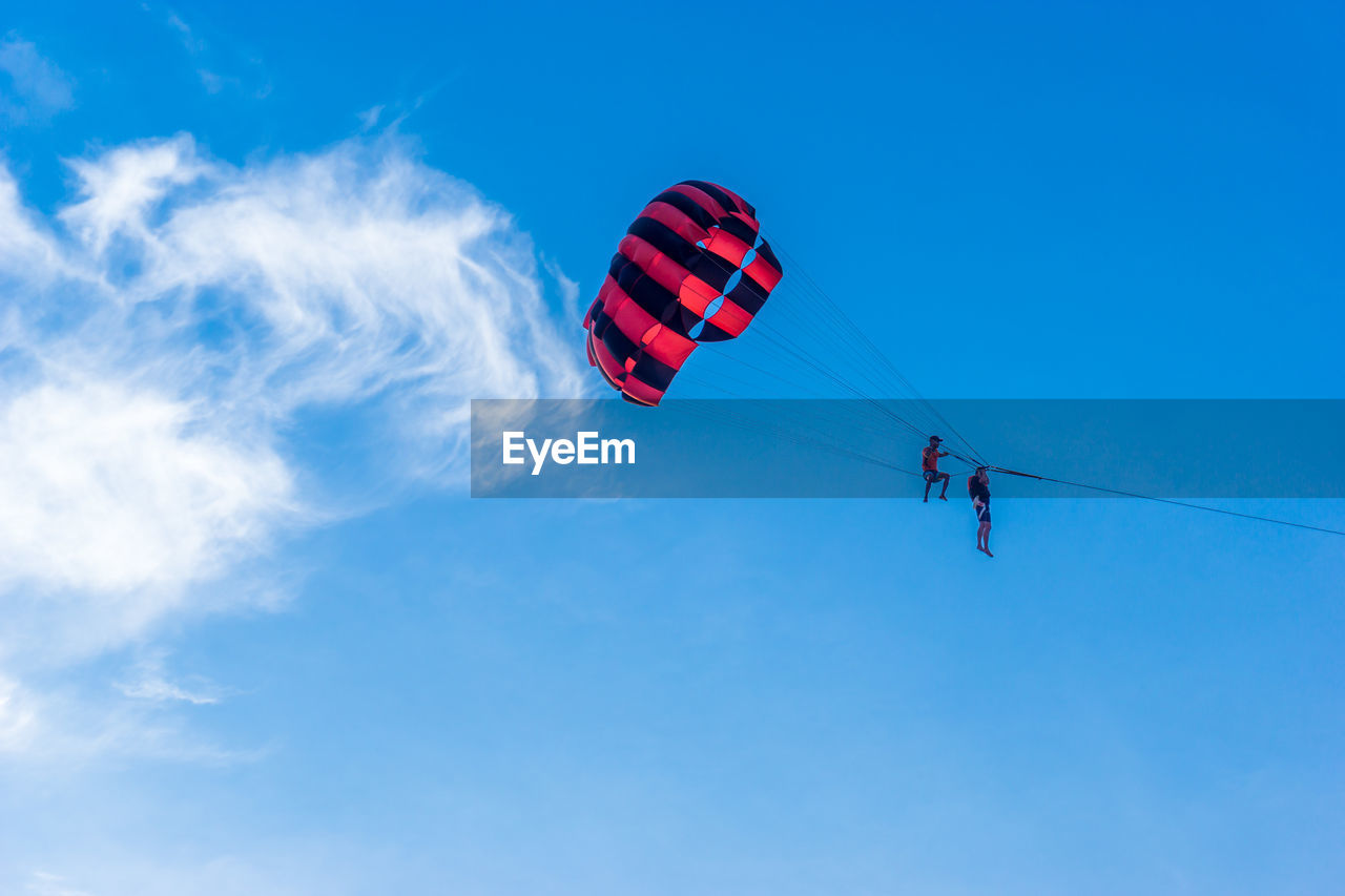 LOW ANGLE VIEW OF KITE FLYING AGAINST BLUE SKY