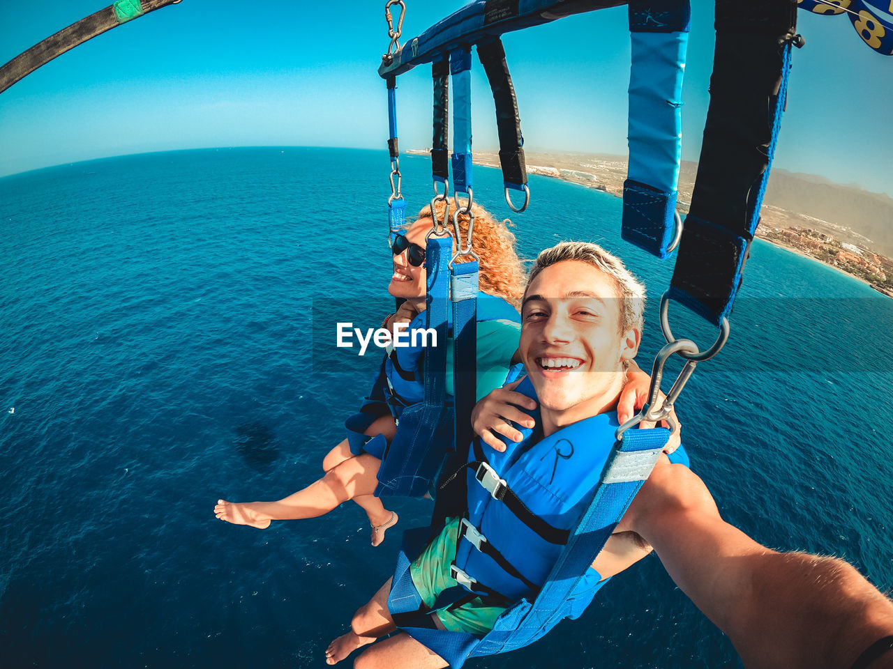 Portrait of man paragliding above sea