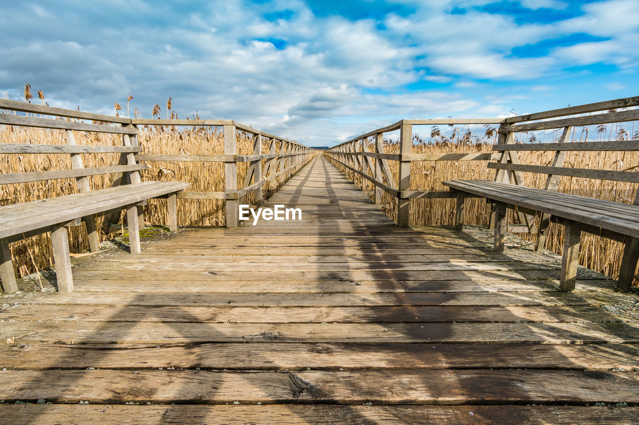 EMPTY WOODEN FOOTBRIDGE ALONG FOOTPATH