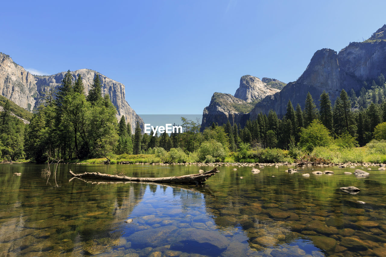 Scenic view of lake against clear blue sky