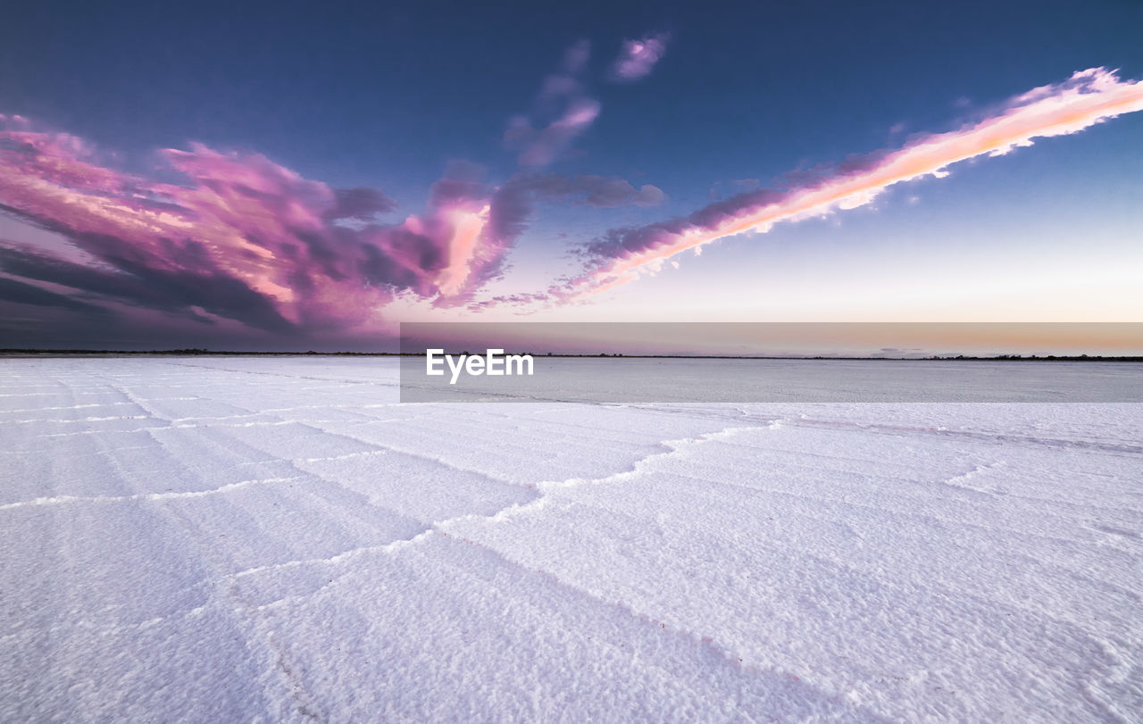 Scenic view of salt lake against sky during sunset