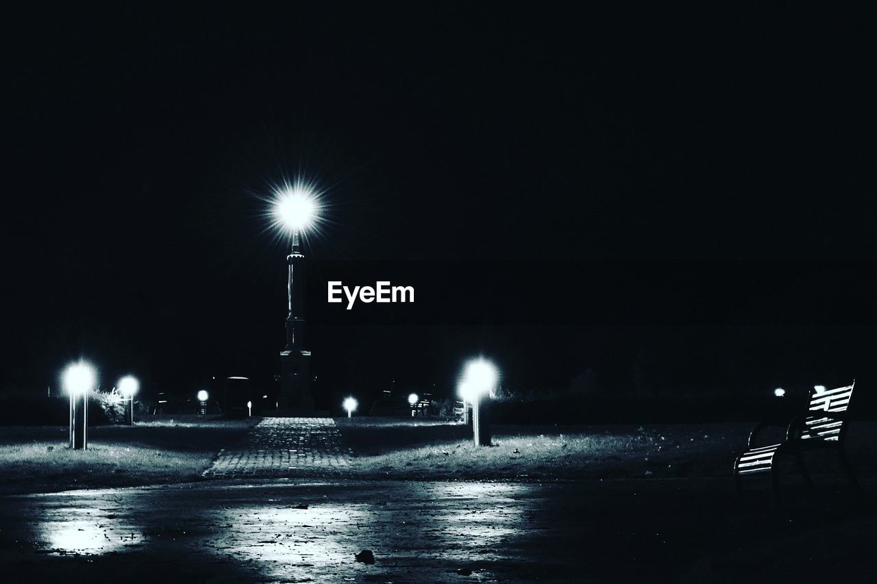 VIEW OF ILLUMINATED STREET LIGHTS AT NIGHT