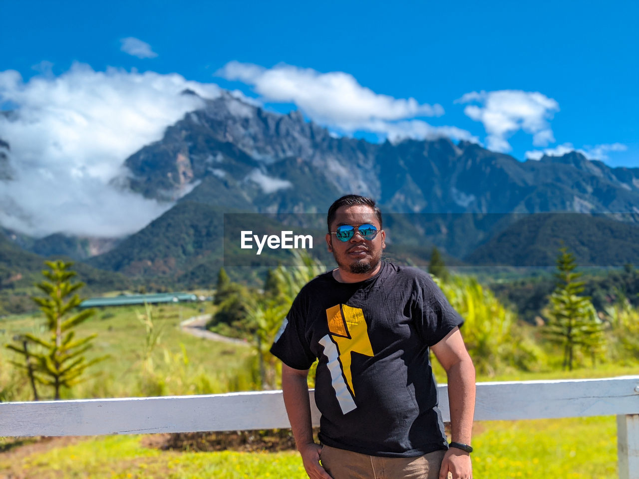 PORTRAIT OF MAN STANDING IN MOUNTAINS