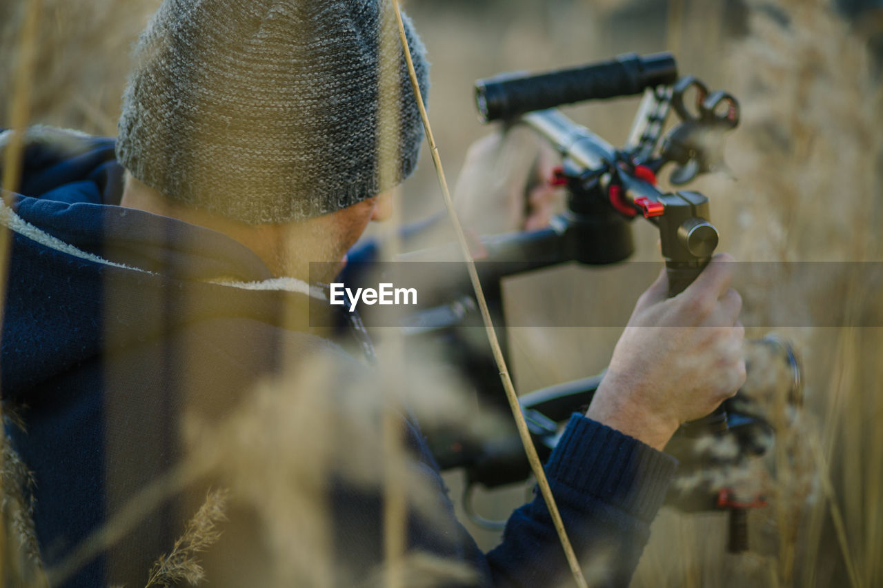 Photographer adjusting shoulder mount camera in field