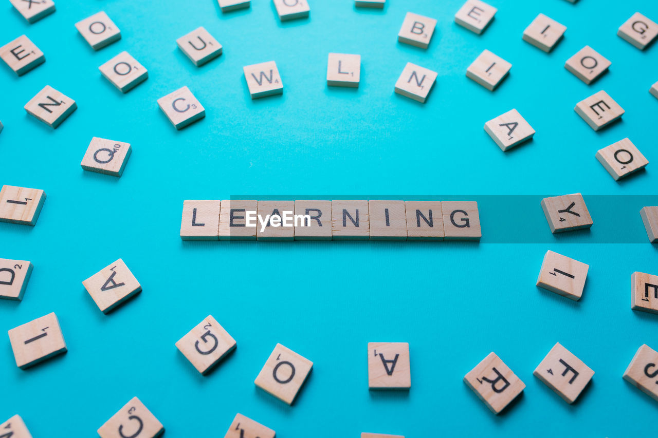 Word learning formed by wooden letters on a light blue background