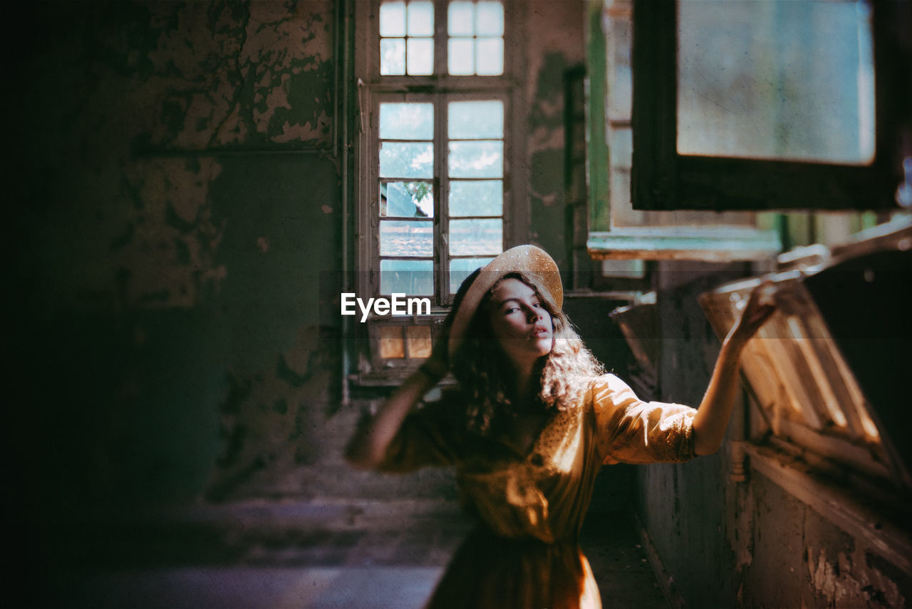 Girl in old derelict building with sunlight streaming in