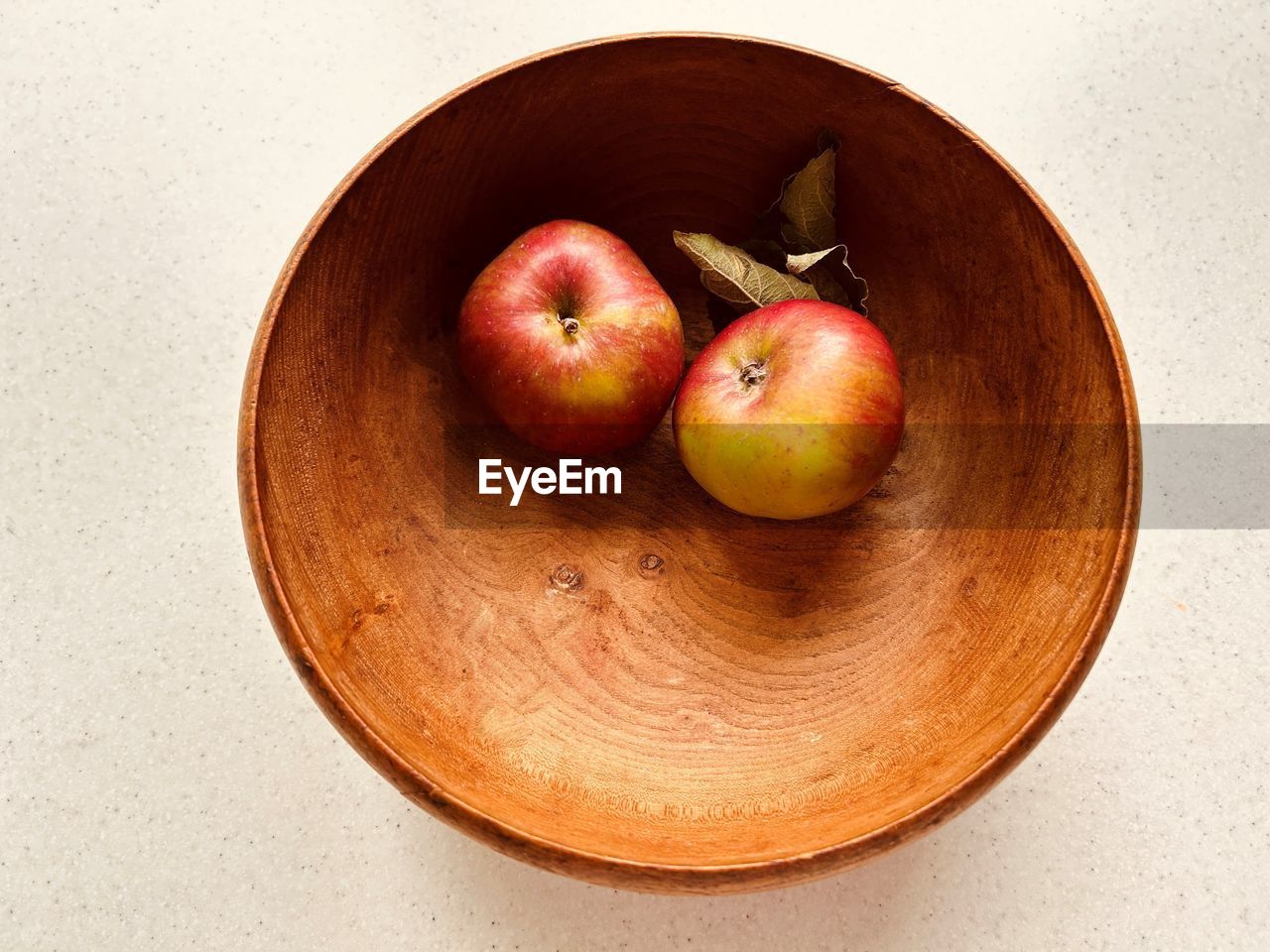 Two apples in wooden bowl. red and green apples. foraged in community orchard. fresh and juicy.