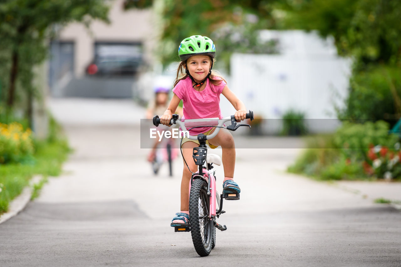 PORTRAIT OF HAPPY GIRL RIDING BICYCLE ON MOTORCYCLE