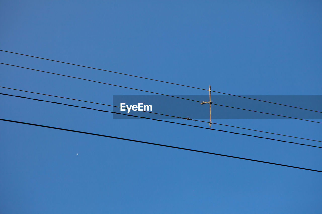 LOW ANGLE VIEW OF POWER LINES AGAINST BLUE SKY