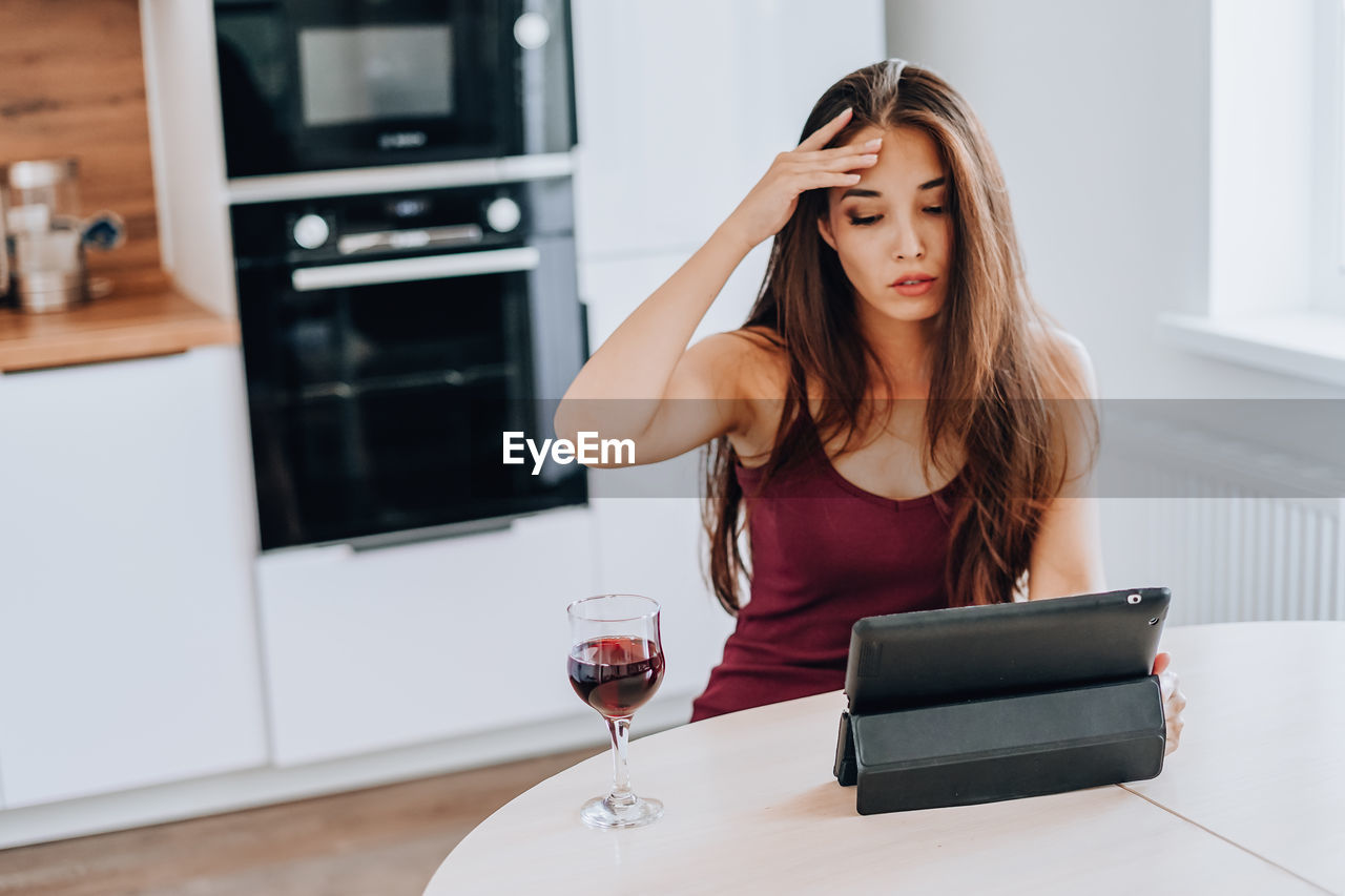 YOUNG WOMAN USING LAPTOP AT HOME