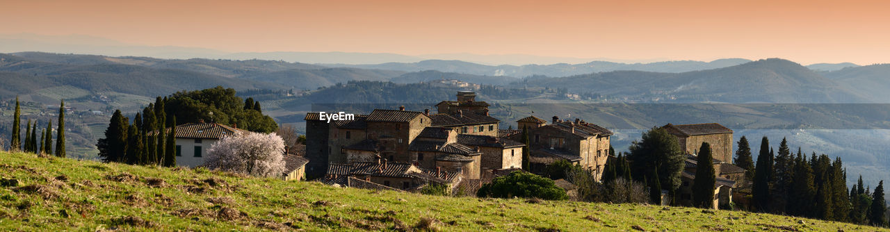 Panoramic view of buildings on mountains against sky during sunset